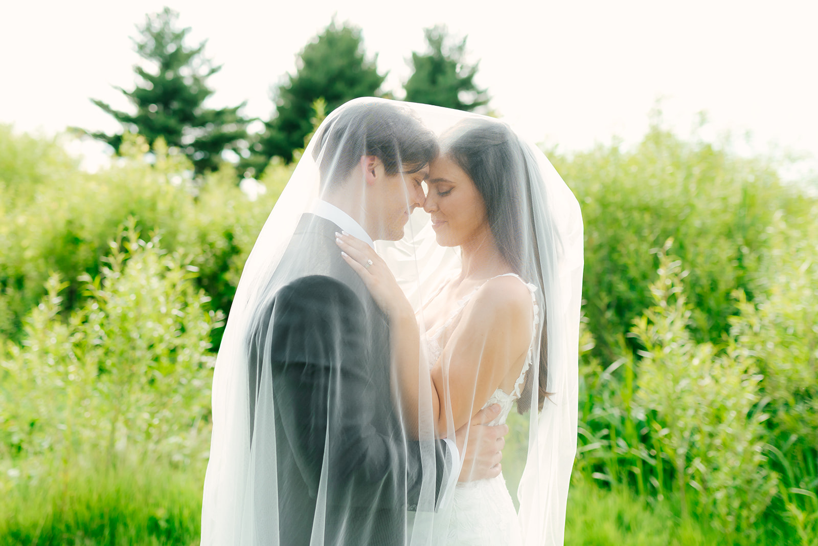 bride and groom under the veil for golden hour