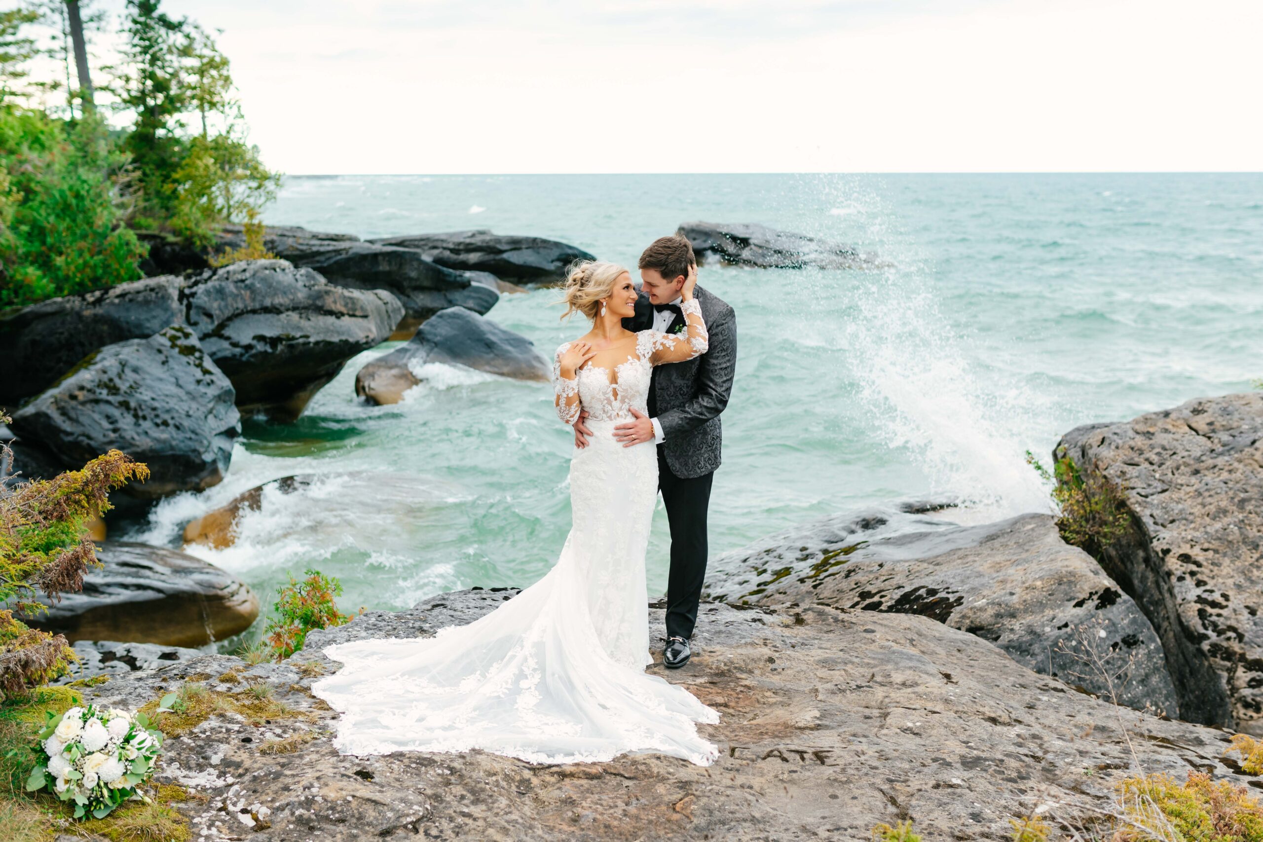 bride and groom at broken rocks beach with waves crashing in the background