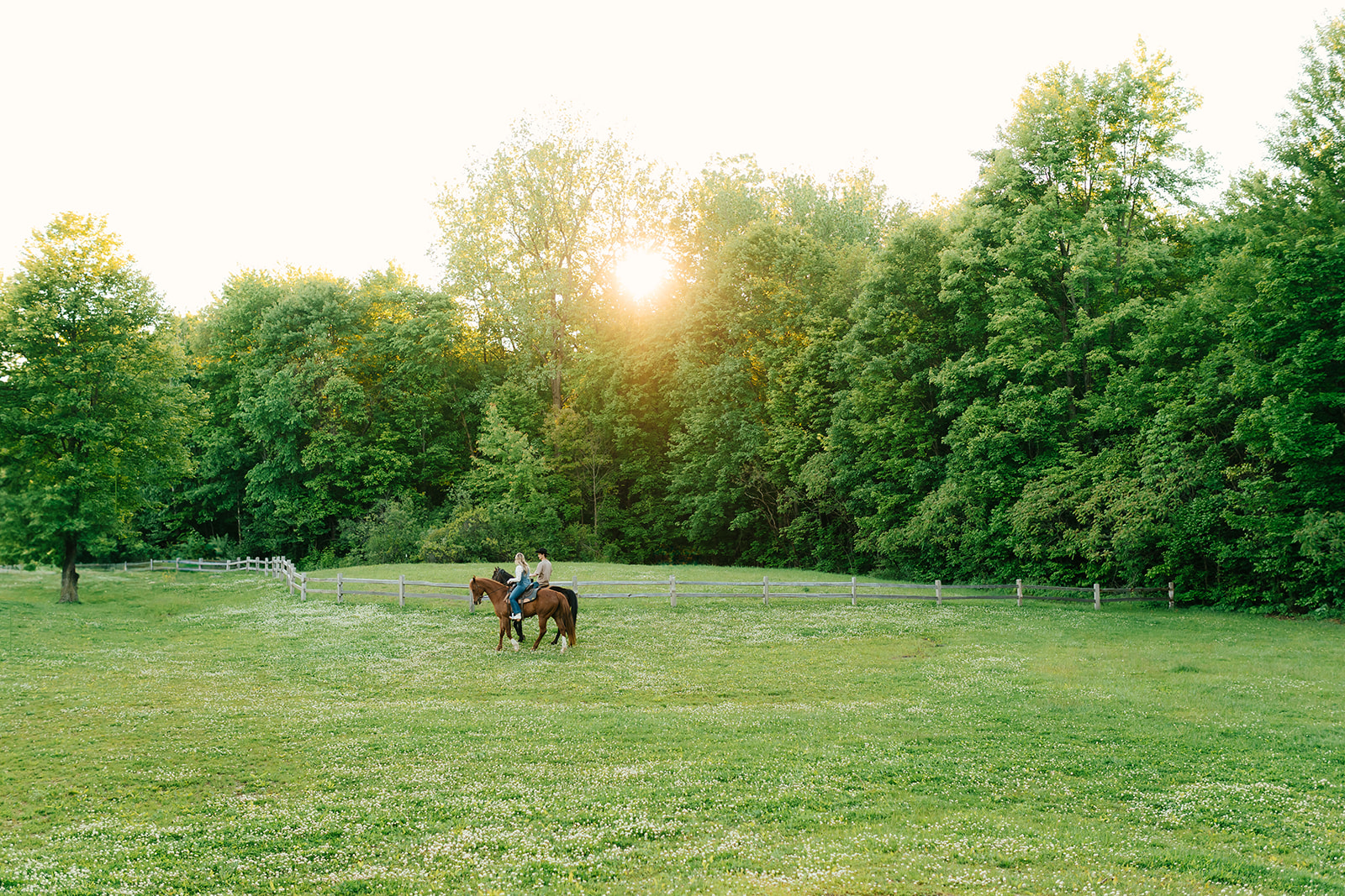 COUPLE riding horses during golden hour for engagement session