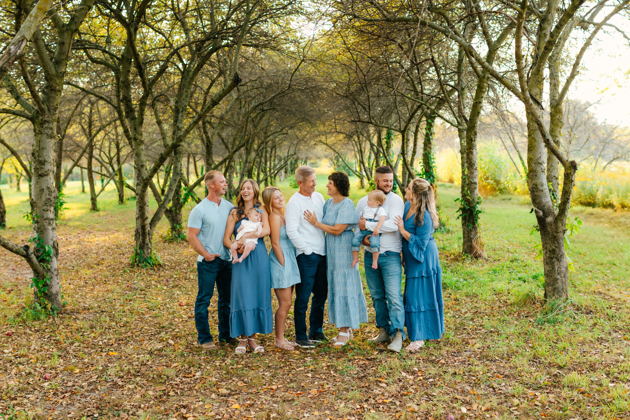 extended family standing together looking at each other for a photo in a grand rapids park