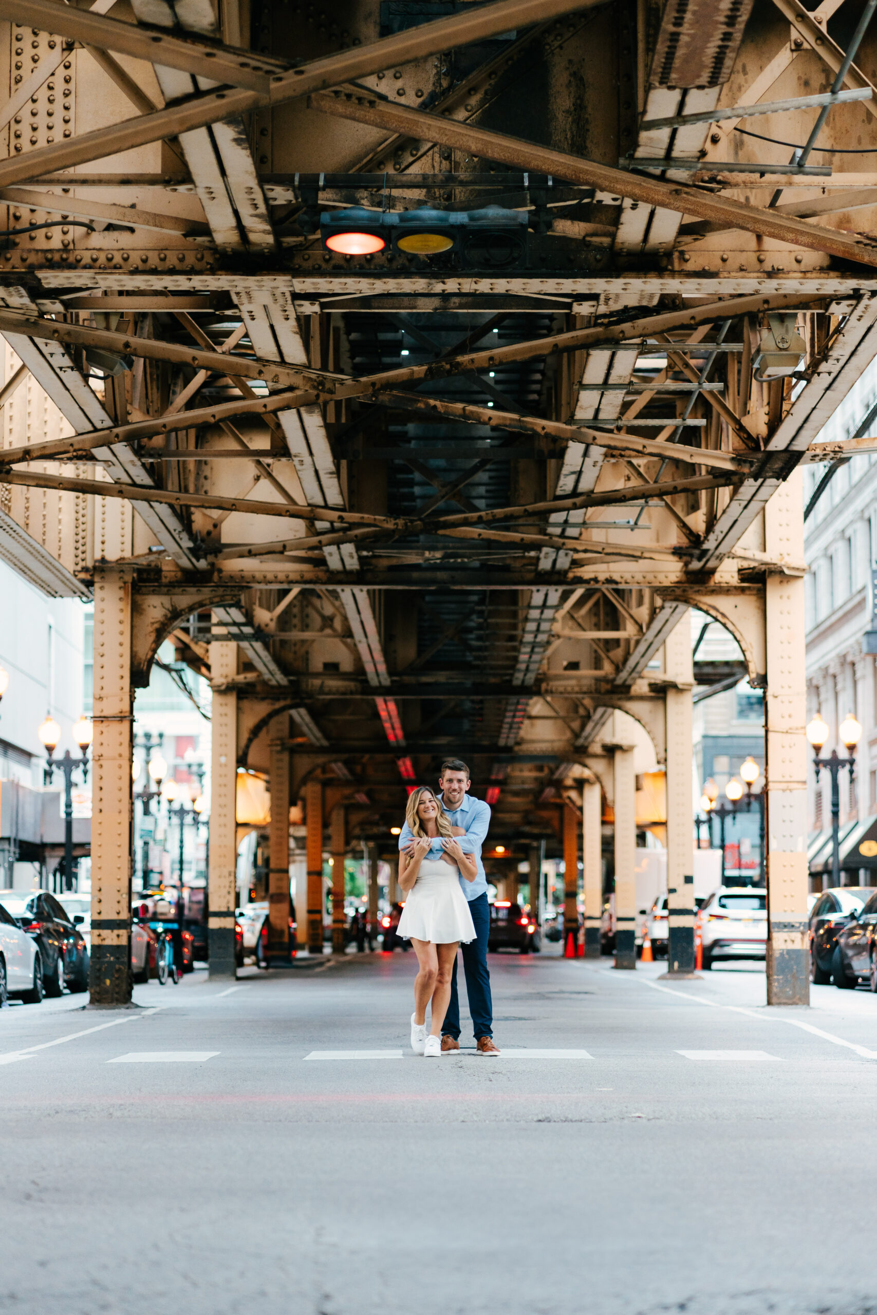 Engagement photo of Hannah and Andrew under the L train tracks using long exposure to capture city movement.