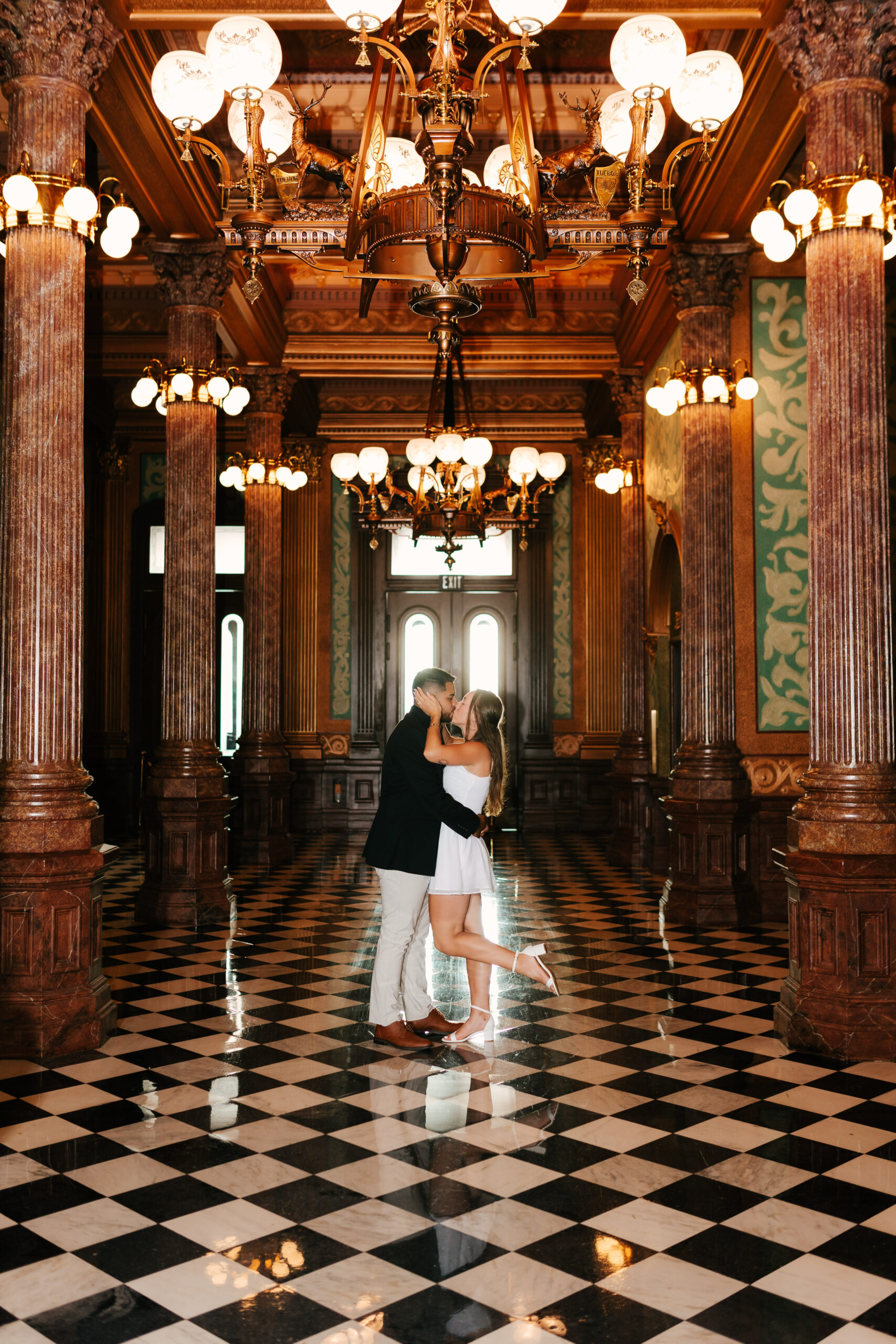 Jessica and Cisco posing in elegant indoor space with vibrant natural tones.