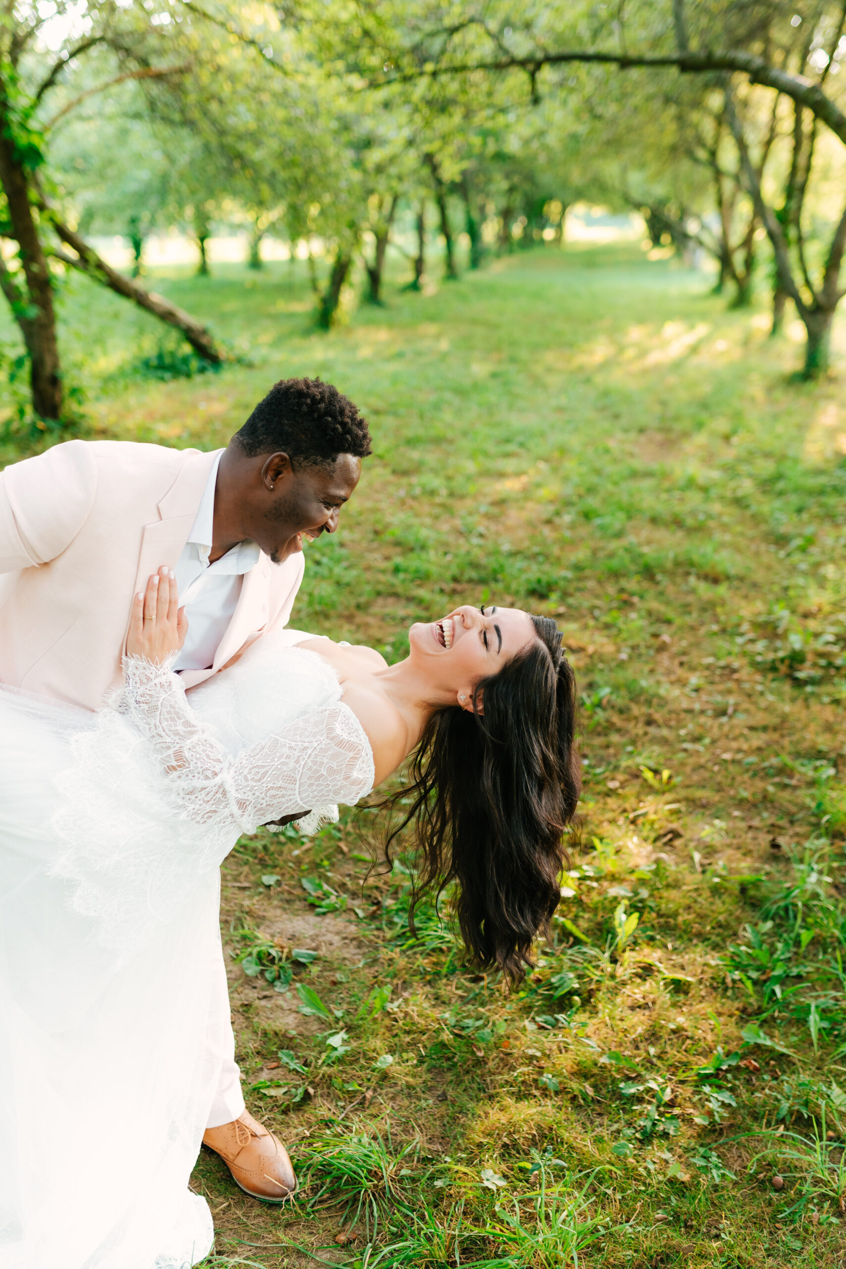 Robert dips Shelby in a joyful, movement-filled pose during their elopement in Michigan, capturing laughter and golden hour romance
